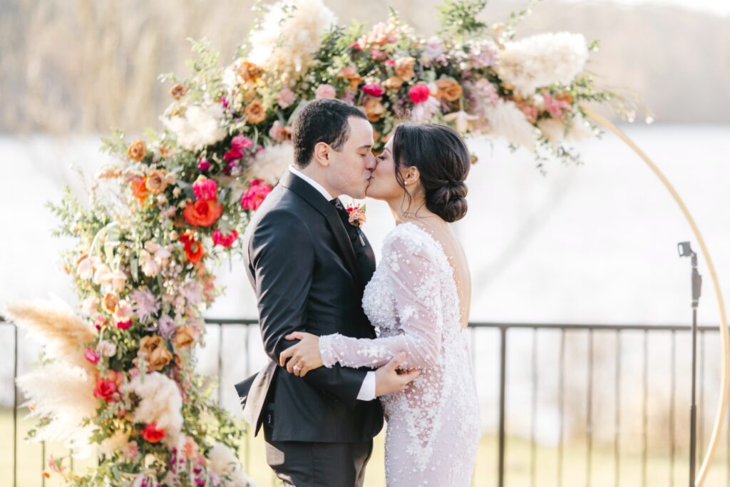 bride & grooms first kiss during outdoor spring wedding ceremony