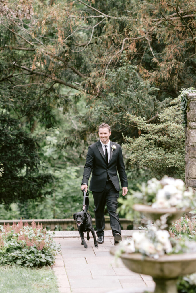 groom walking down the aisle with his dog