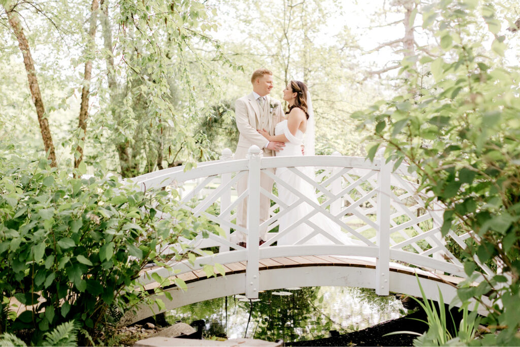 bride & groom on a bride in a garden at Pennsylvania summer wedding by Emily Wren Photography