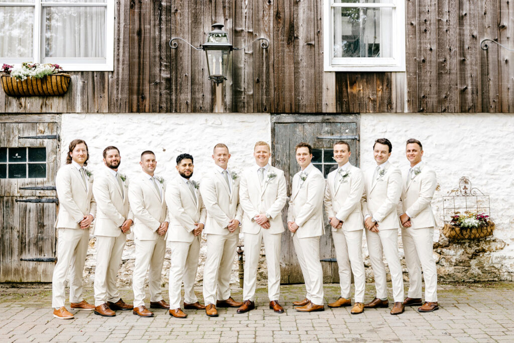 groom with his groomsmen dressed in cream colored suits