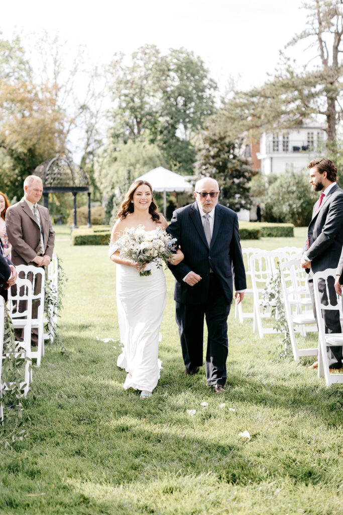 bride walking down the aisle at outdoor summer wedding ceremony