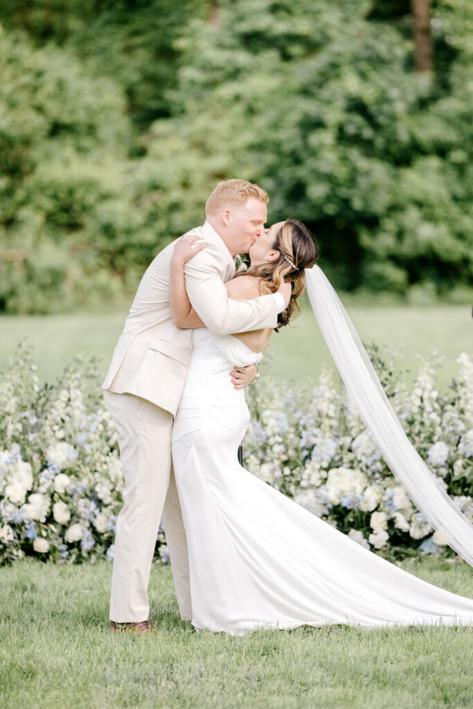 bride & grooms first kiss at outdoor wedding ceremony