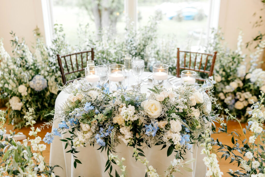 white, blue & greenery floral decor for sweetheart table at spring wedding reception