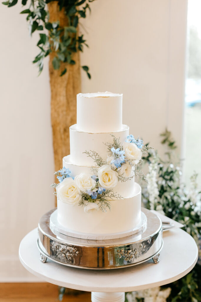 4 tier wedding cake with white & blue flowers