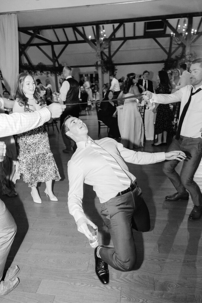 wedding guests doing the limbo by Emily Wren Photography