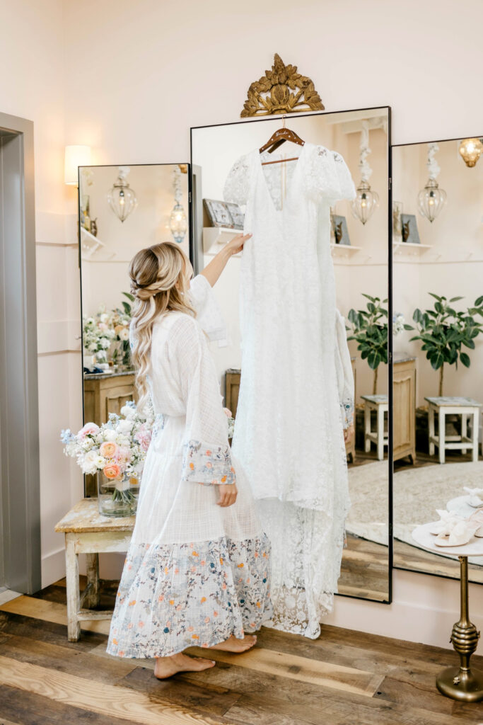 bride looking at her wedding gown as she gets ready for her summer wedding day