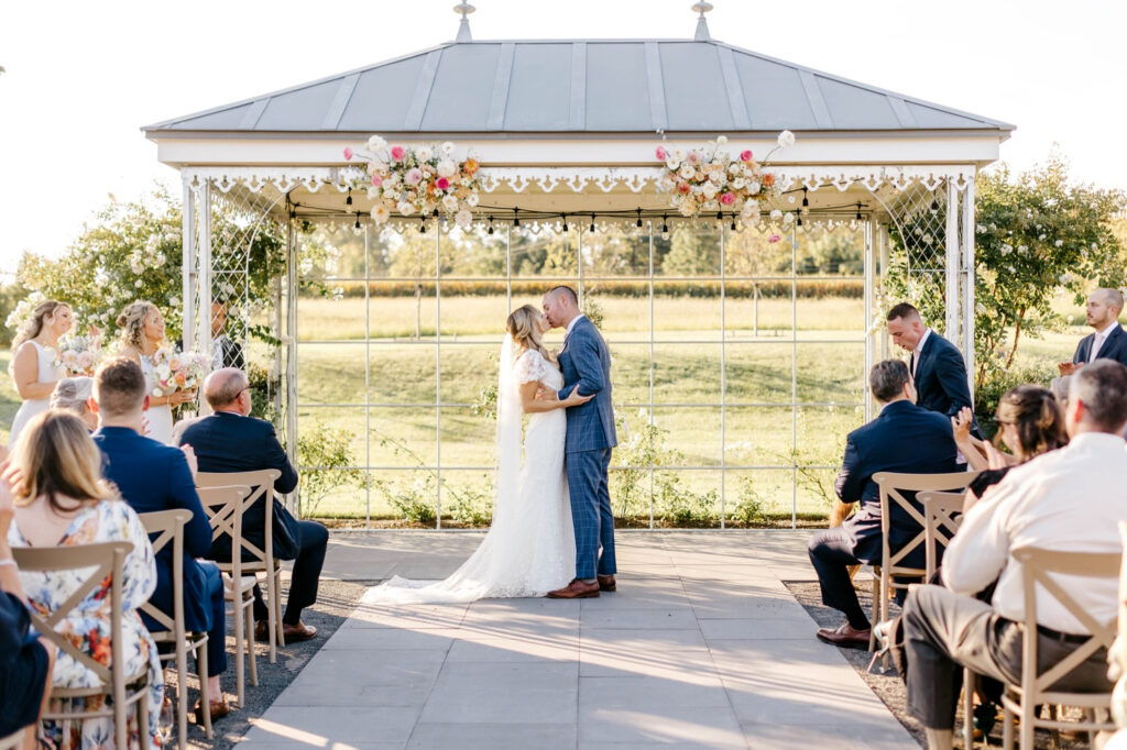 bride & grooms first kiss at Terrain Gardens wedding by Emily Wren Photography