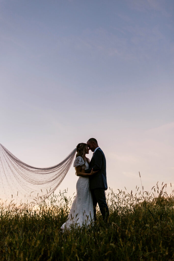 bride & groom purple sunset portrait by Emily Wren Photography