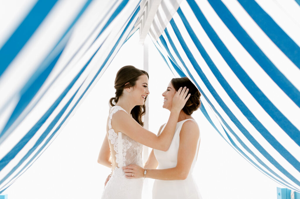 LGTBQ brides under a blue and white tent by Emily Wren Photography