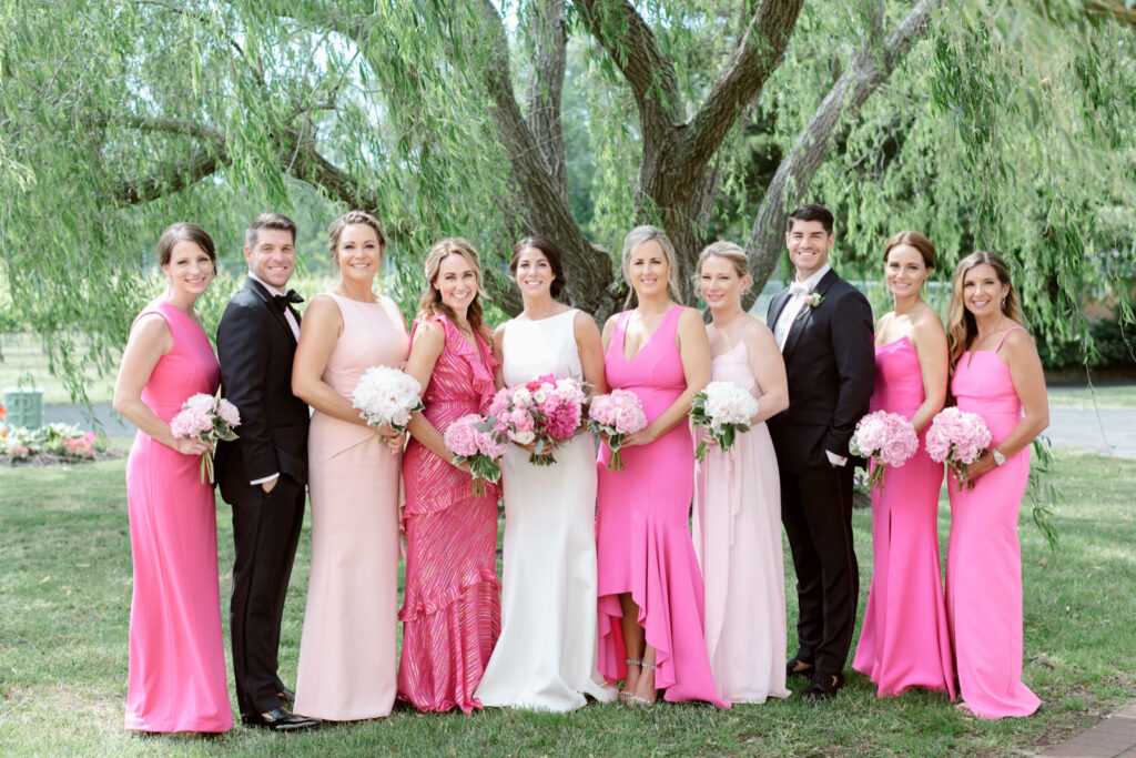 bride with bridesmaids and bridesmen in hot pink and blush pink wedding attire