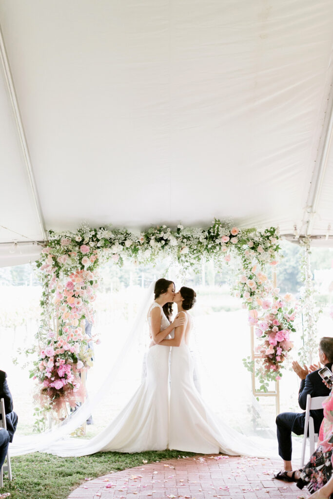 same sex wedding couple brides first kiss at outdoor wedding ceremony by Emily Wren Photography