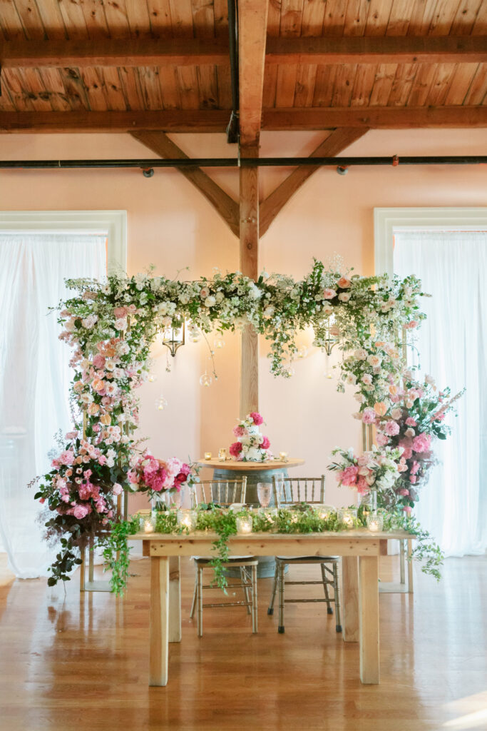 pink floral sweetheart table for summer wedding reception at Willow Creek Winery by Emily Wren Photography