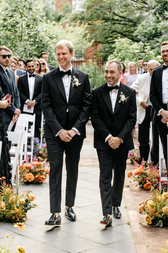 LGBTQ grooms walking down the aisle together by Emily Wren Photography