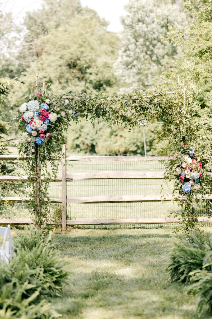 vibrant pink, blue & white floral wedding ceremony arch