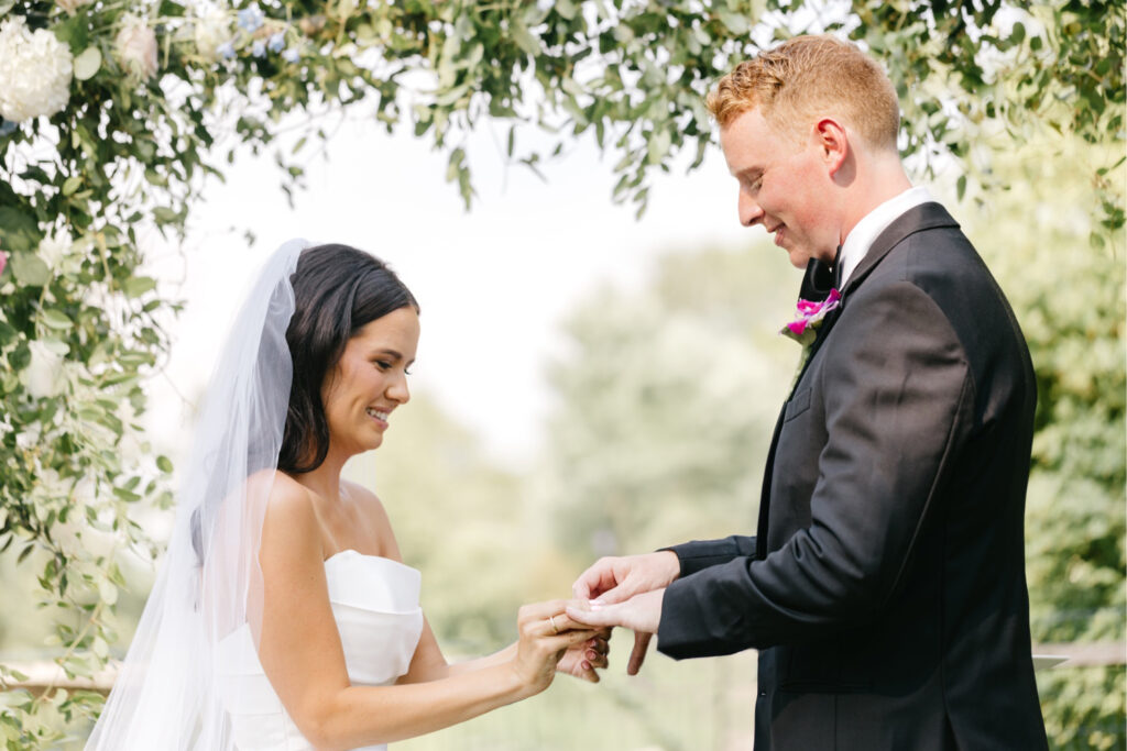 bride & groom exchanging rings at outdoor summer wedding ceremony