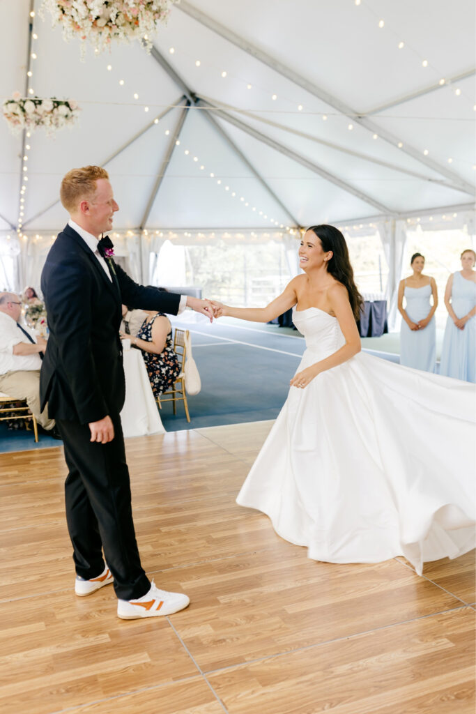 bride & grooms first dance during their outdoor wedding ceremony under a white tent