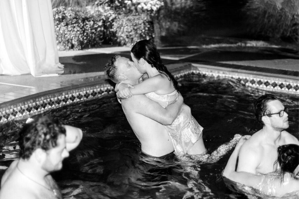 bride & groom kissing in the pool at their Pennsylvania estate wedding reception by Emily Wren Photography