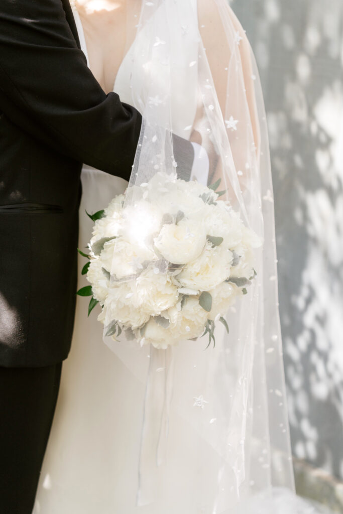 all white bridal bouquet under constellation bridal veil