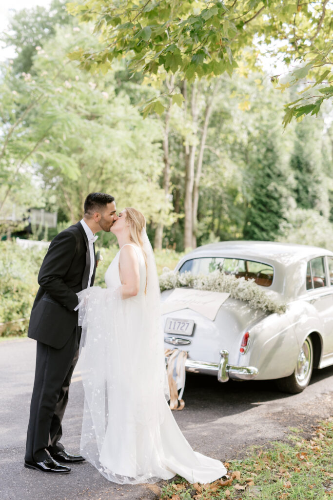 bride & groom posing in front of vintage rolls royce car