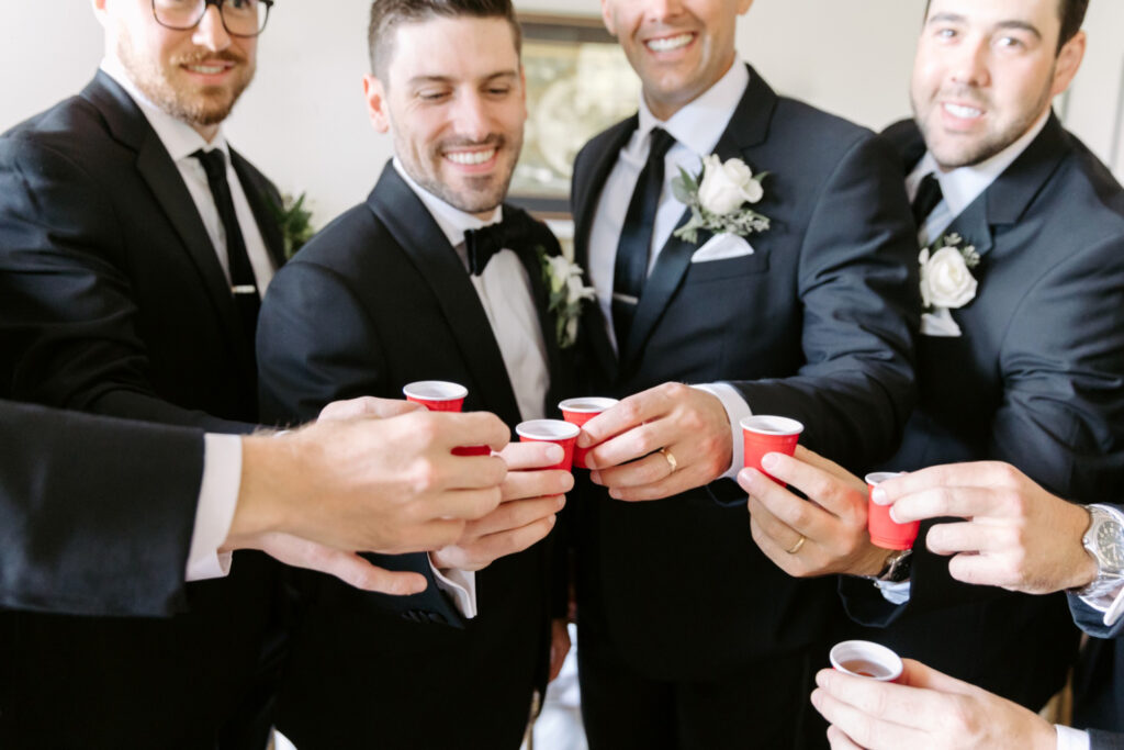 groom and groomsmen taking shots while getting ready for wedding day at the Inn at Barley Sheaf