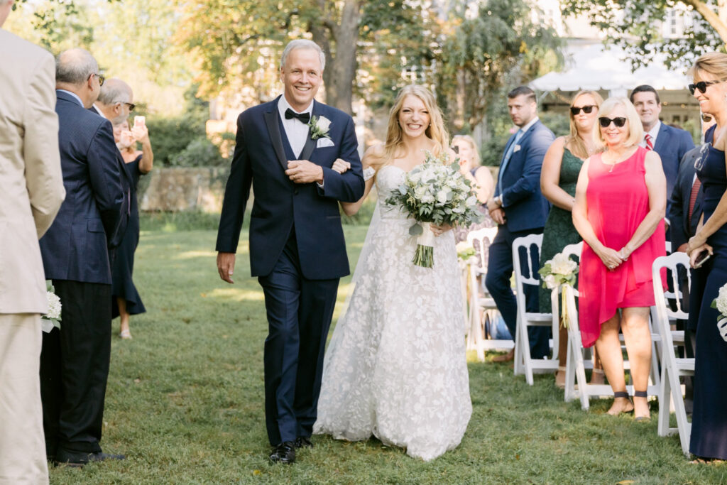 bride walking down the aisle at outdoor wedding ceremony by Emily Wren Photography