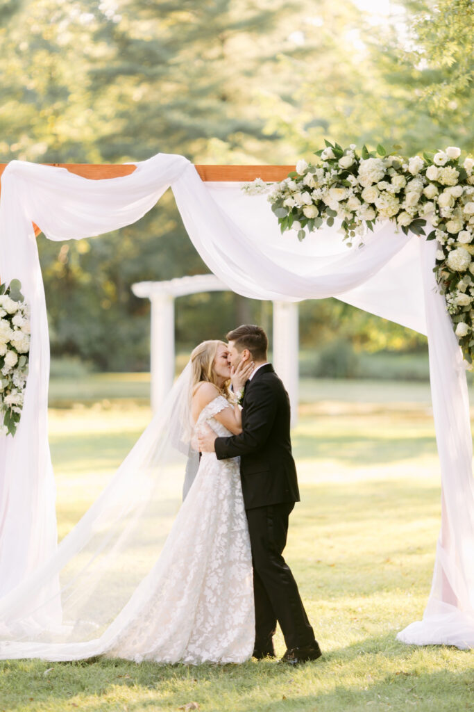 bride & grooms first kiss at outdoor wedding garden ceremony at the Inn at Barley Sheaf