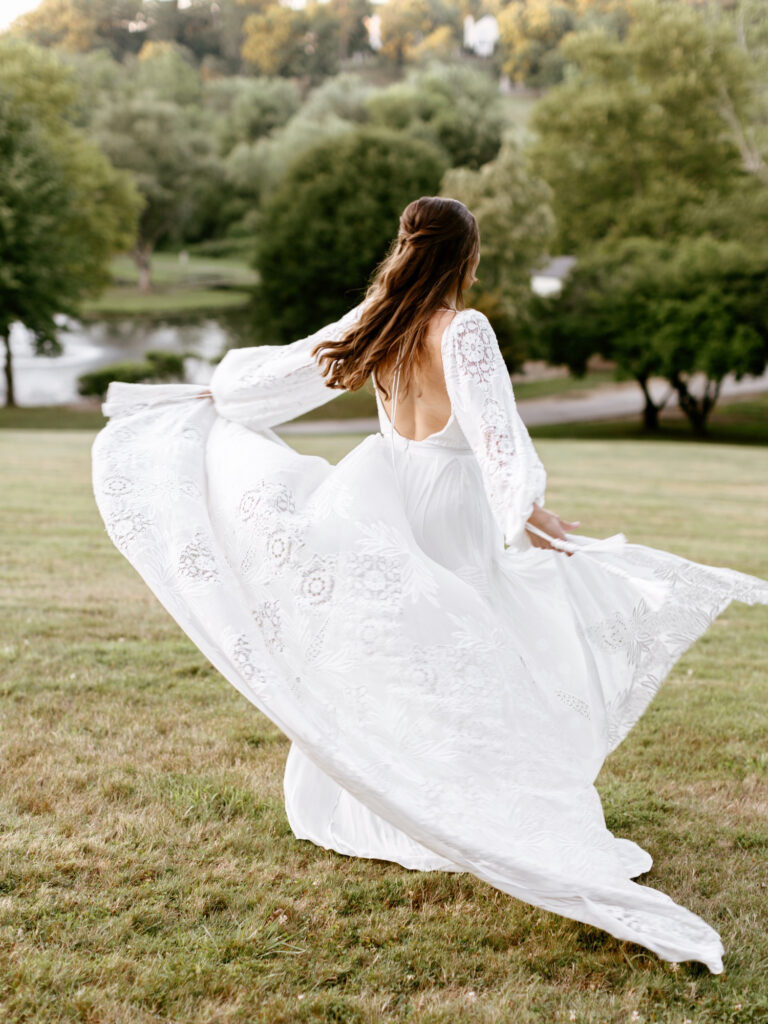 whimsical bride running through field at The Willows wedding venue