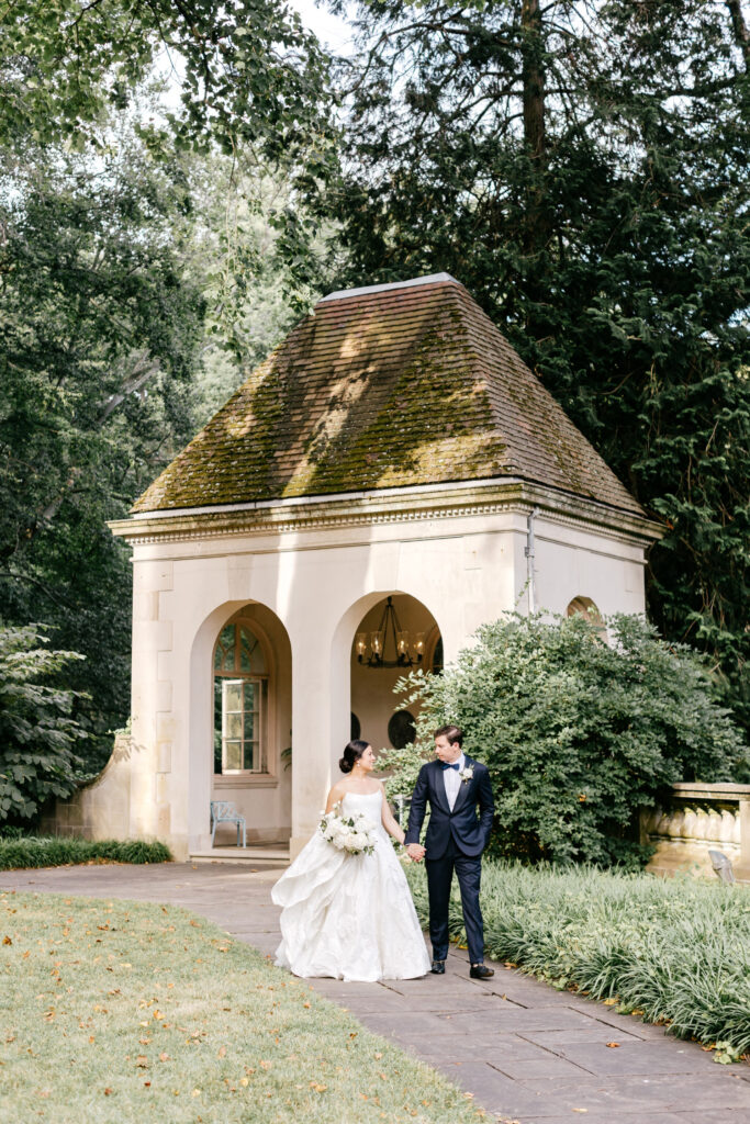 bride & groom walking through Delaware garden by Emily Wren Photography