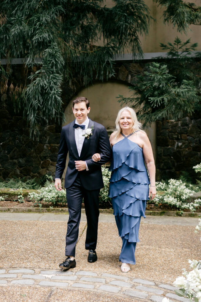 groom walking down the aisle with his mother for outdoor wedding ceremony