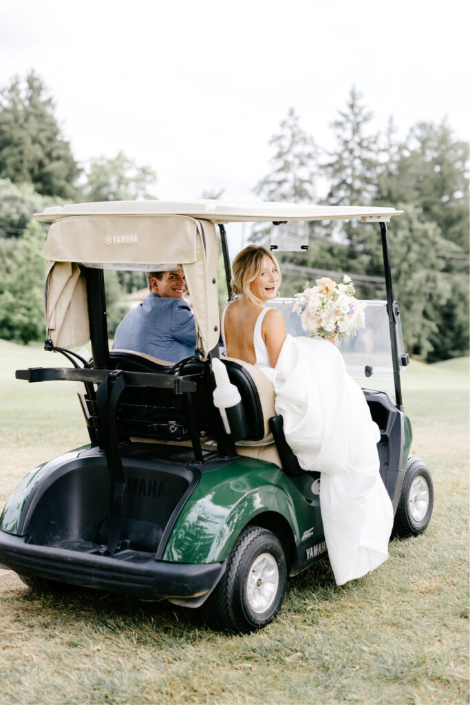 bride & groom riding a golf club at Gulph Mills Golf Club