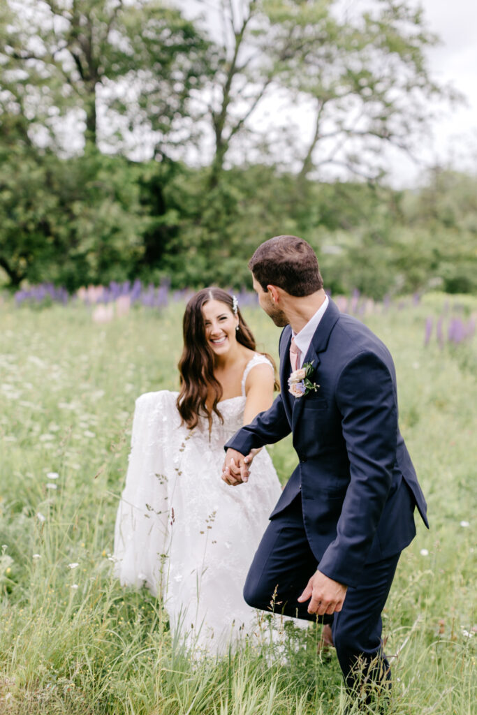 bride & groom in purple flower field in Vermont by Emily Wren Photography