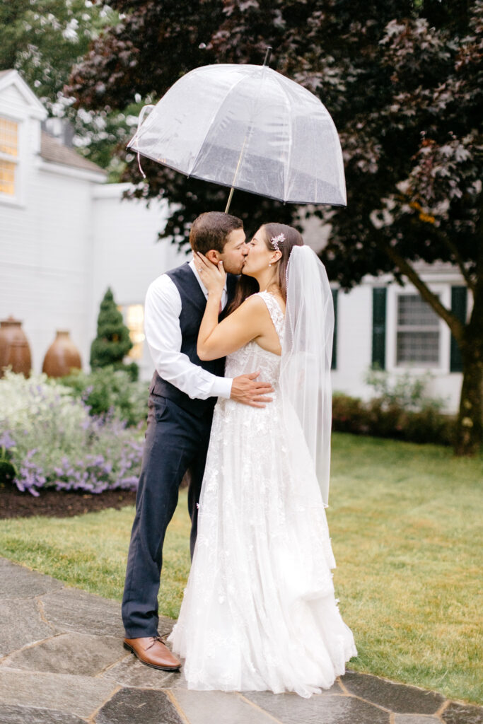 Vermont bride & groom kissing in the rain at their wedding reception