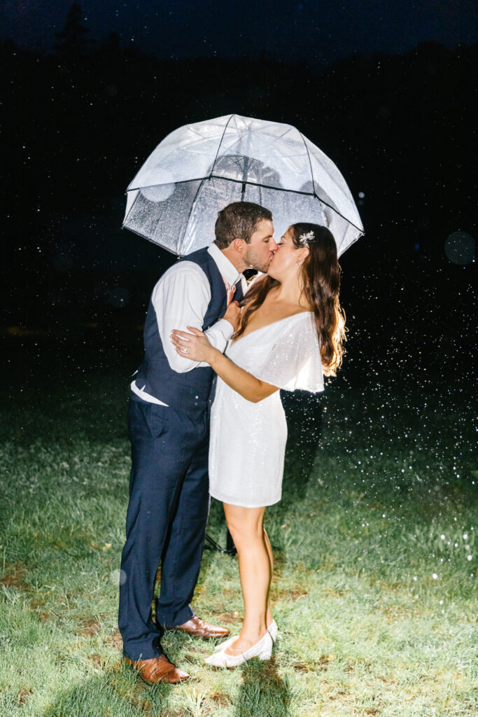 bride & groom kissing in the rain at night in Vermont by Emily Wren Photography