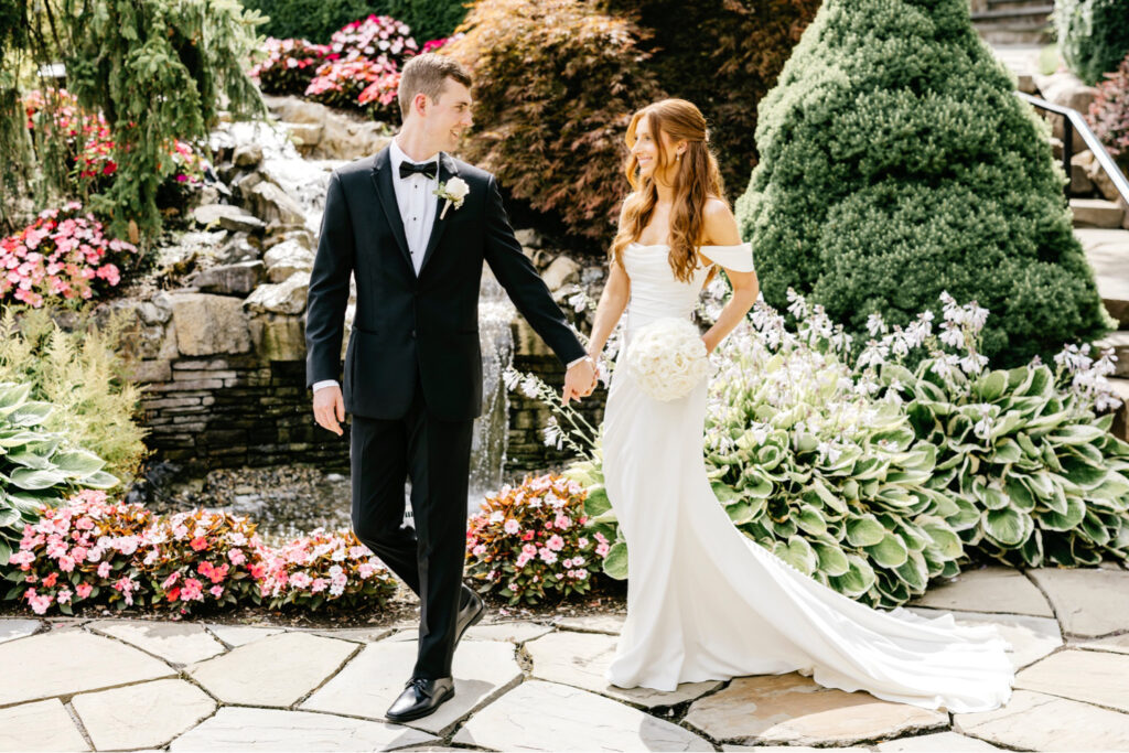 bride & groom walking through Park Savoy Estate garden by luxurious wedding photographer Emily Wren Photography