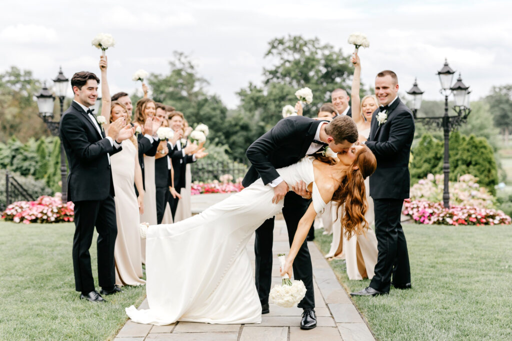 bride and groom kissing in the middle of their wedding party at New Jersey Estate wedding venue