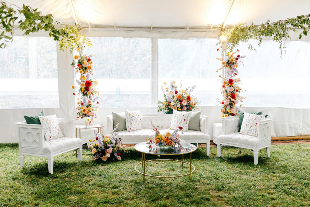 cocktail hour lounge area at Appleford Estate wedding reception filled with colorful floral displays by Emily Wren Photography