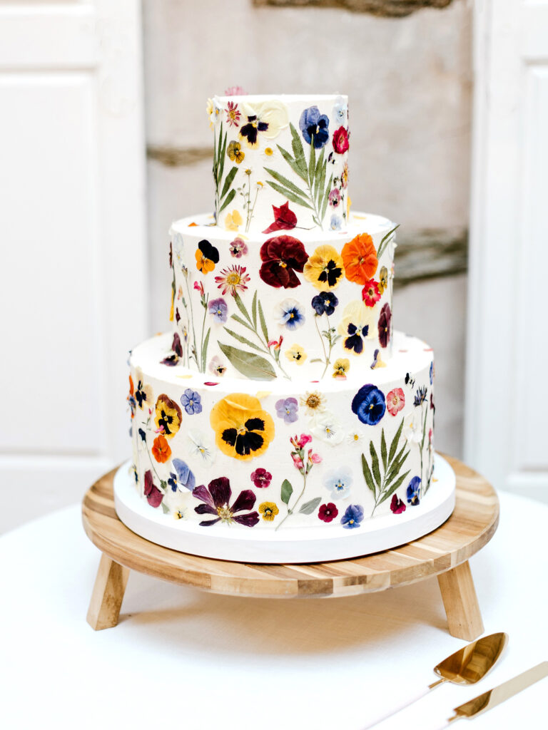 3 tier wedding cake with colorful floral pressings and decal by Emily Wren Photography