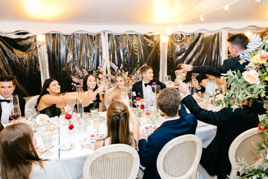 guests toasting at white tent summer wedding reception