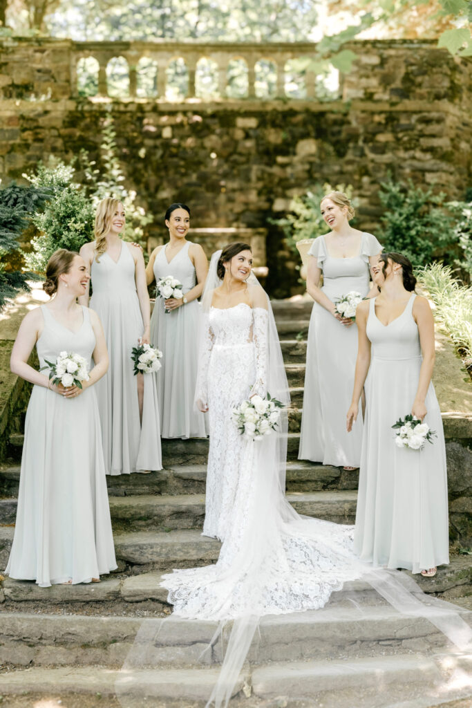 bride with bridesmaids in light green bridesmaid dresses by Emily Wren Photography