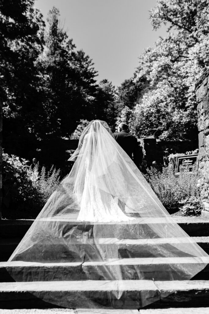 bride walking down the aisle with her veil blowing in the wind at Parque Ridley Creek