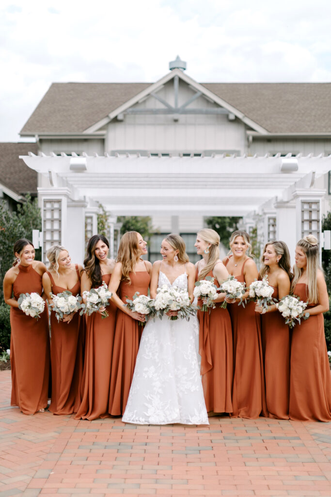 bride with bridesmaids in burnt orange bridesmaid dresses for Autumn wedding day in Maryland