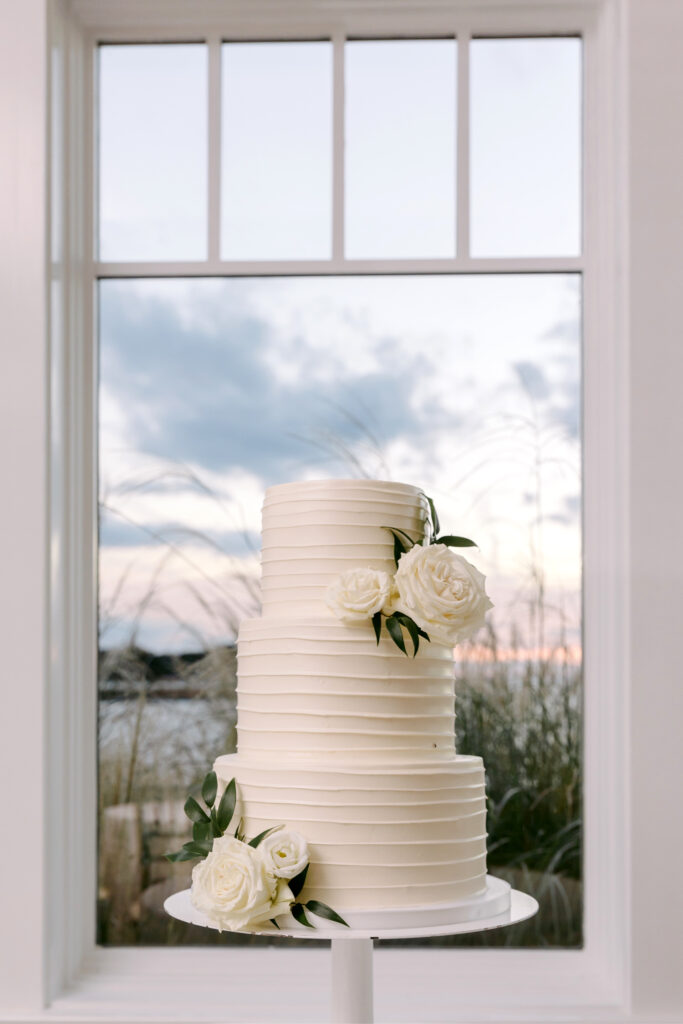 3 tier simple wedding cake with sunset in the background