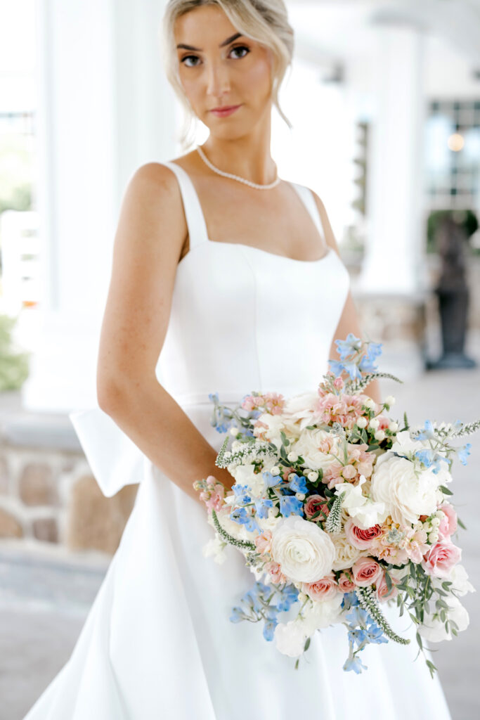 pastel summer bridal bouquet of blue, pink, and white flowers