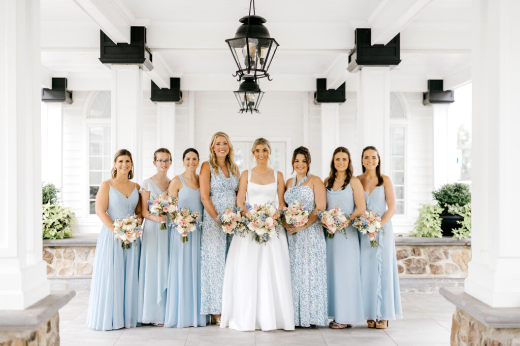 bride with her bridesmaids in coordinating light blue bridesmaid dresses