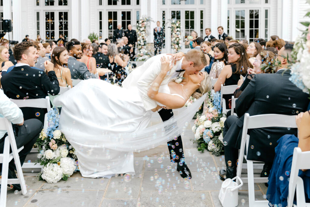 bride & groom kissing during their wedding ceremony bubble exit