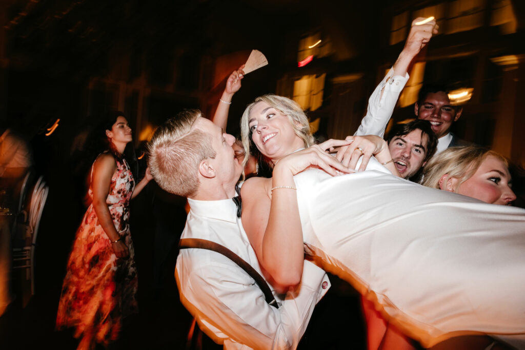 bride crowdsurfing at wedding reception at The Ryland Inn by Emily Wren Photography