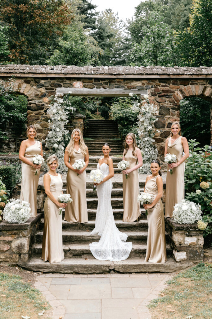 bride with bridesmaids in champagne gold bridesmaid dresses at Parque Ridley Creek by Emily Wren Photography