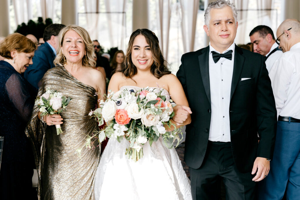 bride walking down the aisle with both of her parents by Emily Wren Photography