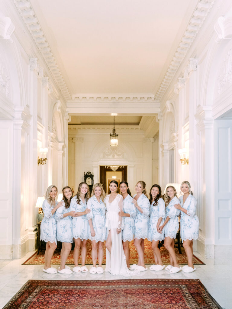 bride with bridesmaids in matching light blue floral satin robes by Emily Wren Photography