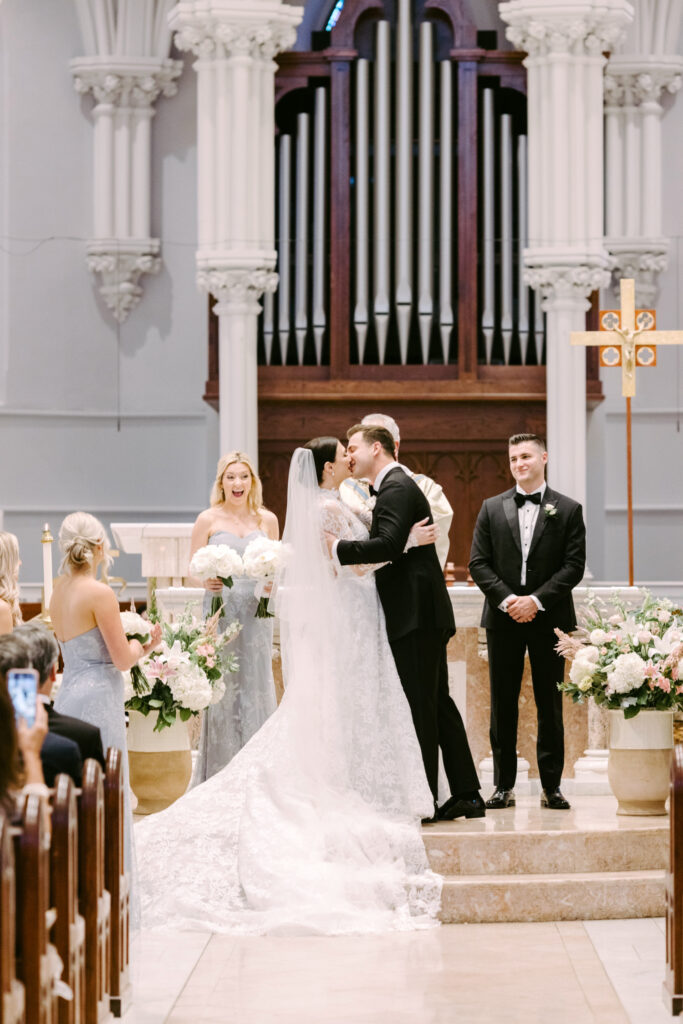 bride and grooms first kiss at St. Thomas of Villanova Church